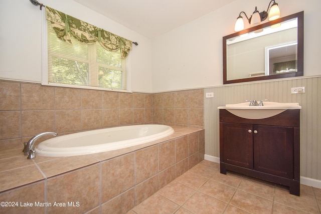 bathroom with tile patterned floors, tiled bath, and vanity