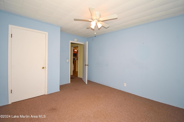 unfurnished room with ceiling fan, crown molding, and light colored carpet