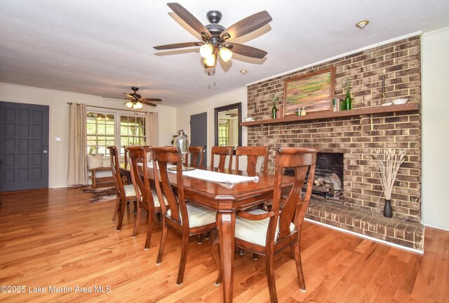 514 Sleepy Holw, Alexander City, AL 35010 - dining space with light wood finished floors, ceiling fan, and a fireplace