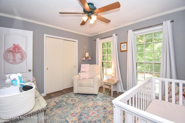 514 Sleepy Holw, Alexander City, AL 35010 - bedroom featuring wood finished floors, a nursery area, a closet, ornamental molding, and ceiling fan