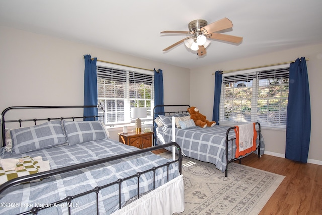 bedroom featuring multiple windows, ceiling fan, and hardwood / wood-style flooring