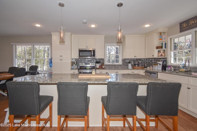 kitchen with sink, a center island, stone countertops, and appliances with stainless steel finishes