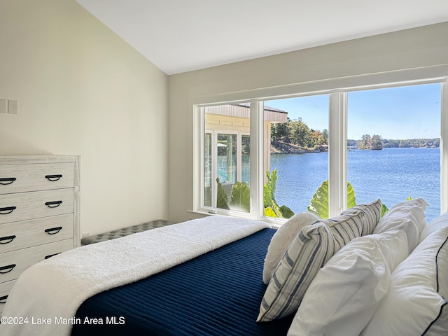 bedroom featuring a water view and vaulted ceiling