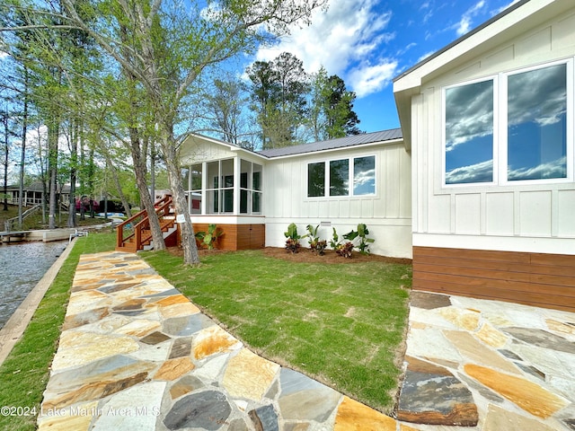 exterior space with a lawn and a sunroom