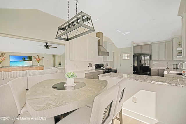 dining area with light hardwood / wood-style floors, vaulted ceiling, ceiling fan, and sink