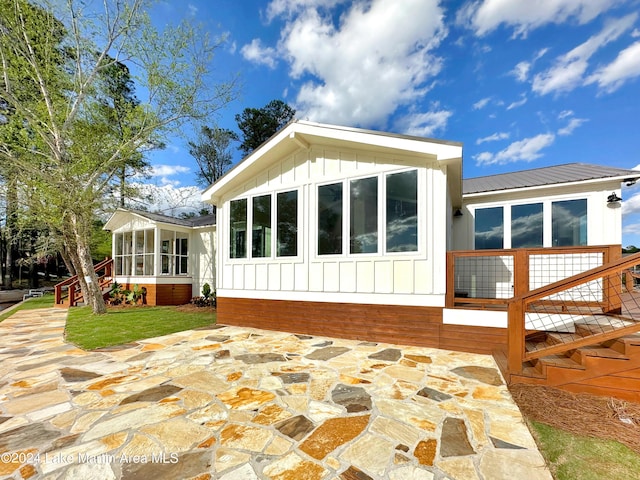 back of property featuring a patio area and a sunroom