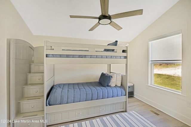 bedroom featuring ceiling fan, light hardwood / wood-style floors, and lofted ceiling