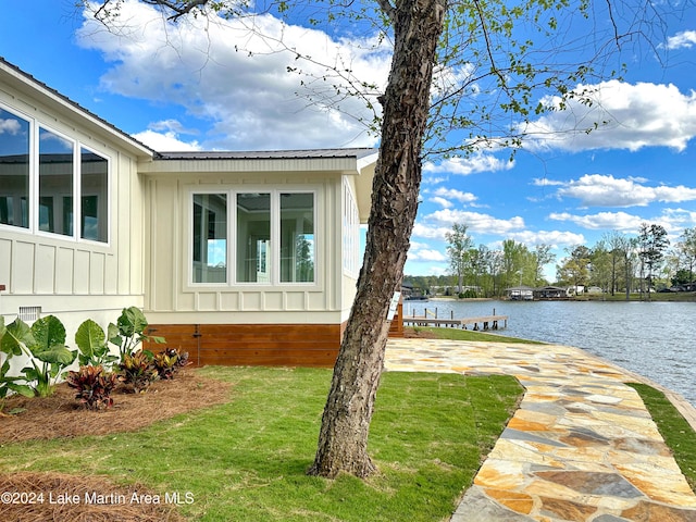 view of property exterior featuring a water view and a yard