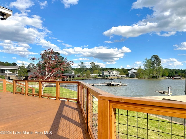 wooden terrace featuring a lawn and a water view