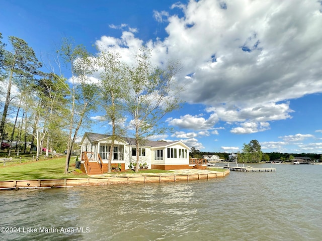 rear view of house with a water view and a sunroom