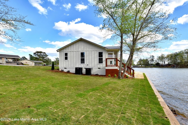 view of side of property featuring a lawn and a water view