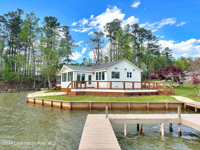 view of dock featuring a lawn and a water view