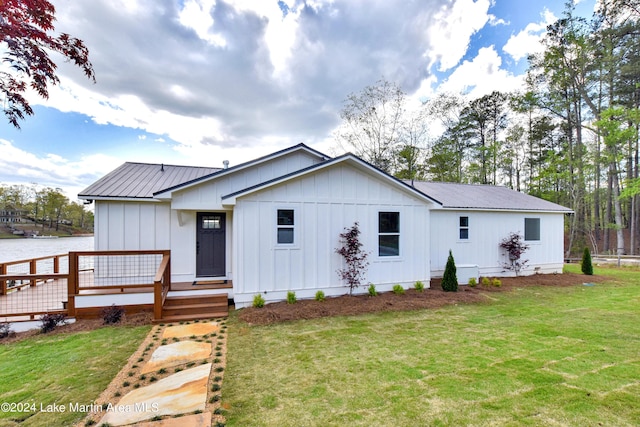 modern inspired farmhouse featuring a front yard and a deck