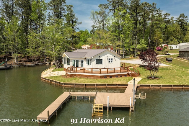 dock area featuring a deck with water view and a yard