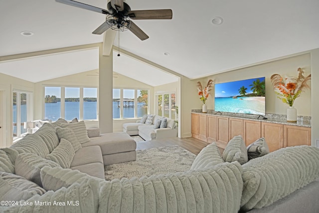 living room featuring ceiling fan, lofted ceiling with beams, and light hardwood / wood-style flooring