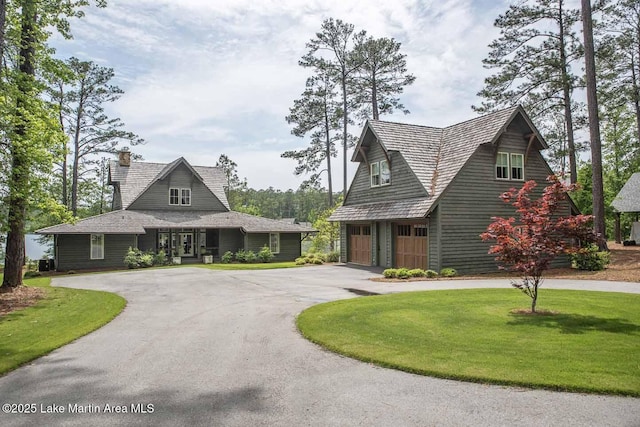 326 Bulgers Mill Loop, Alexander City, AL 35010 - view of front of home with curved driveway, an attached garage, a chimney, and a front yard
