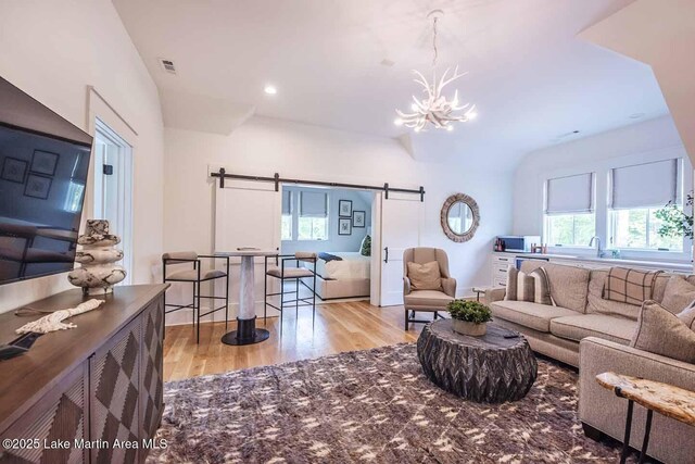 326 Bulgers Mill Loop, Alexander City, AL 35010 - living area with a barn door, wood finished floors, and a chandelier