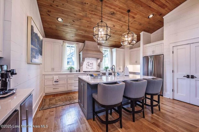 326 Bulgers Mill Loop, Alexander City, AL 35010 - kitchen with vaulted ceiling, premium range hood, white cabinetry, wood ceiling, and wood finished floors