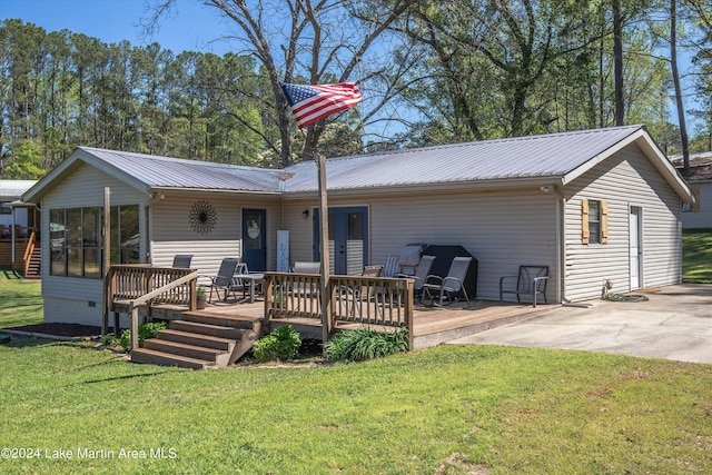 rear view of property featuring a yard and a wooden deck