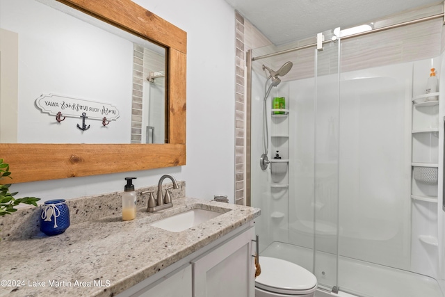 bathroom featuring vanity, toilet, and a shower with door