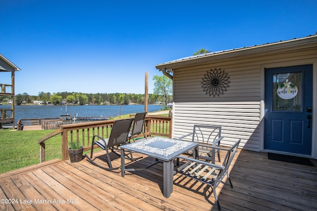 deck with a water view and a lawn