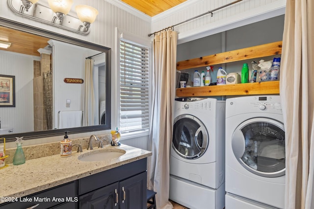 laundry area featuring washer and clothes dryer, a healthy amount of sunlight, sink, and crown molding