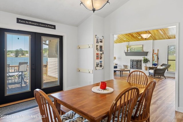 dining space with hardwood / wood-style floors, a water view, wooden ceiling, and french doors