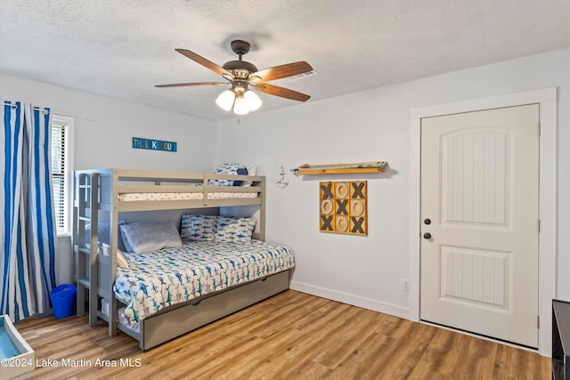 bedroom featuring ceiling fan, a textured ceiling, and hardwood / wood-style flooring