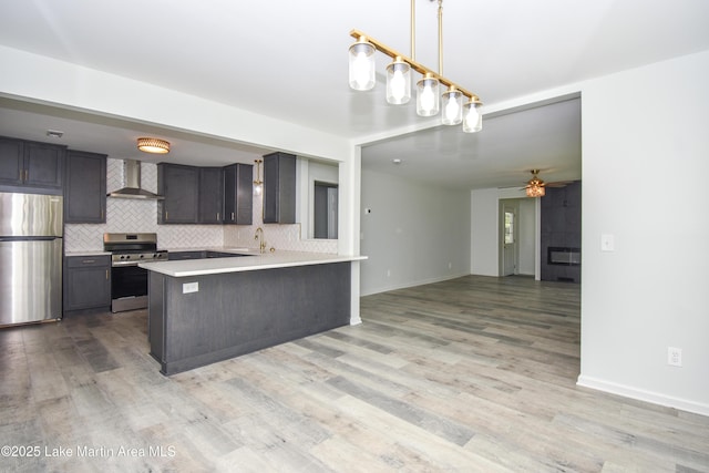 1706 Simpson St, Alexander City, AL 35010 - kitchen featuring stainless steel appliances, wall chimney exhaust hood, light countertops, decorative backsplash, and a peninsula