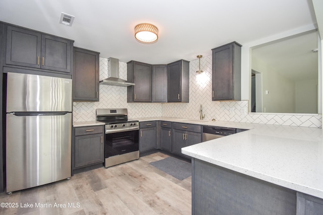 1706 Simpson St, Alexander City, AL 35010 - kitchen with stainless steel appliances, wall chimney exhaust hood, backsplash, light wood-style flooring, and light stone counters