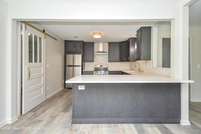 1706 Simpson St, Alexander City, AL 35010 - kitchen featuring stainless steel appliances, wall chimney range hood, decorative backsplash, and light countertops