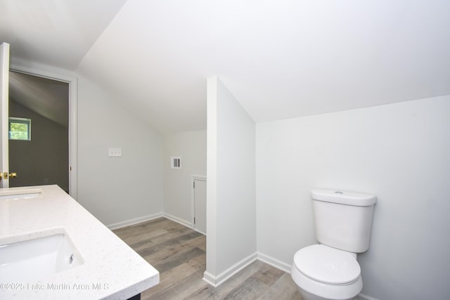 1706 Simpson St, Alexander City, AL 35010 - bathroom featuring vaulted ceiling, wood finished floors, and double vanity