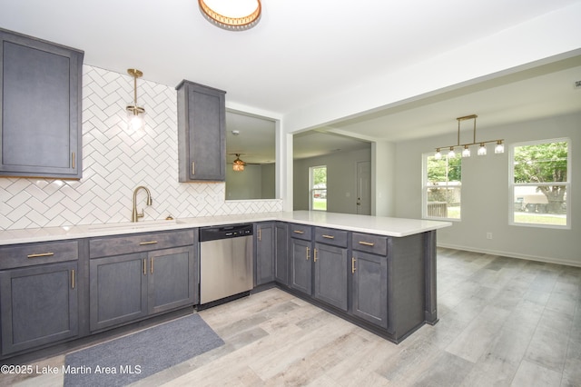 1706 Simpson St, Alexander City, AL 35010 - kitchen with dishwasher, decorative backsplash, light countertops, light wood-type flooring, and hanging light fixtures