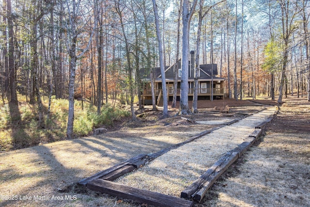 exterior space with a wooded view and a wooden deck