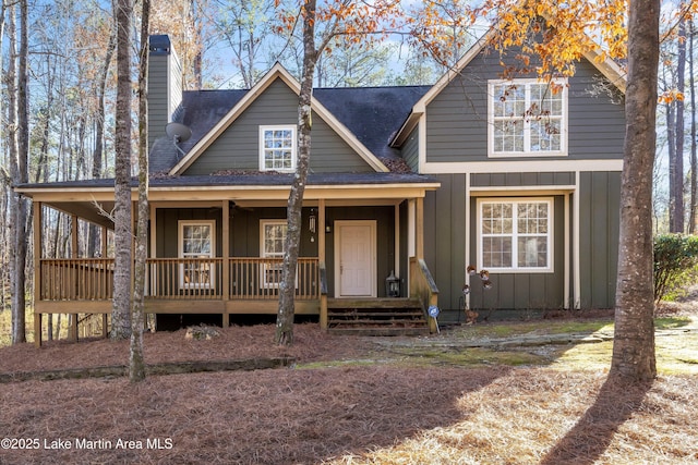 view of front of house featuring a chimney, a porch, board and batten siding, and roof with shingles