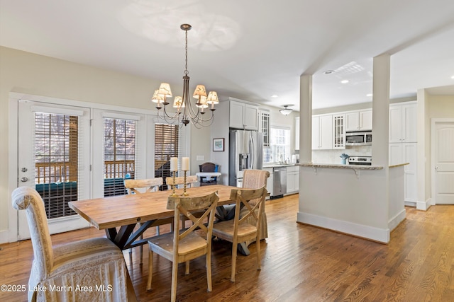 dining space with light wood-style floors, recessed lighting, and an inviting chandelier