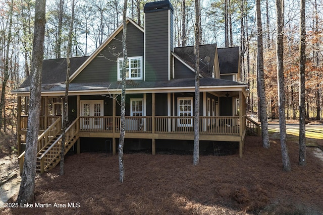 back of house featuring stairway, french doors, roof with shingles, and a chimney