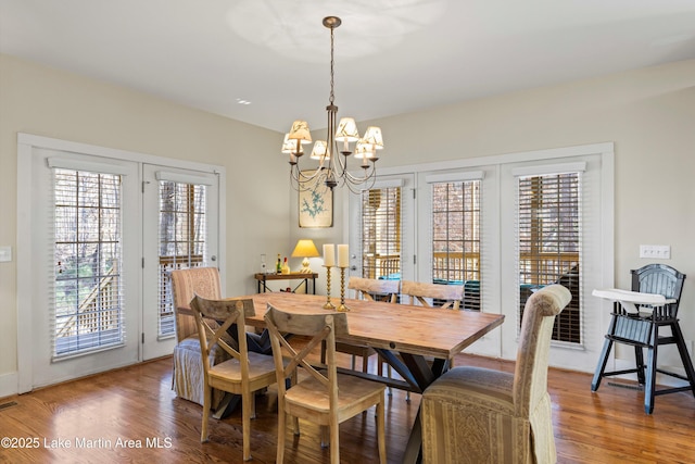 dining space featuring a chandelier, wood finished floors, and visible vents