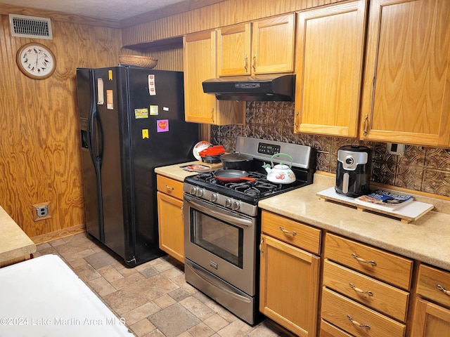 kitchen featuring decorative backsplash, black refrigerator with ice dispenser, and stainless steel range with gas stovetop