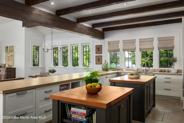 kitchen with white cabinetry, a center island, and wooden counters