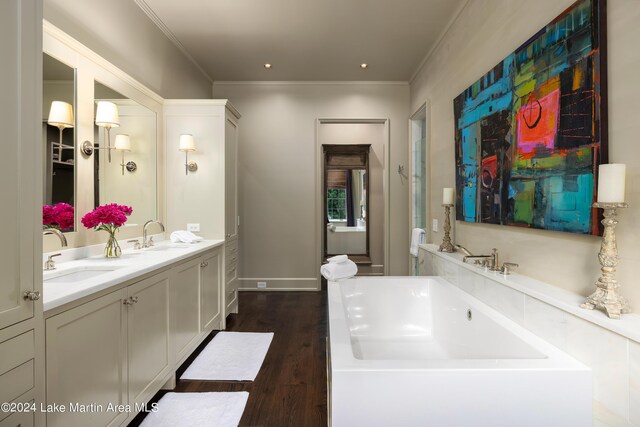 bathroom featuring vanity, a bath, wood-type flooring, and ornamental molding