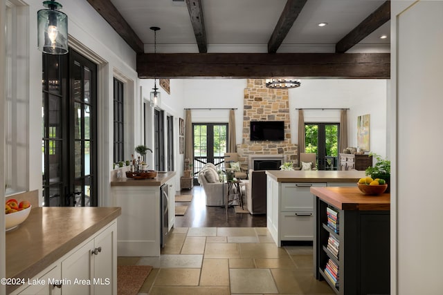 kitchen with white cabinets, plenty of natural light, wooden counters, and french doors