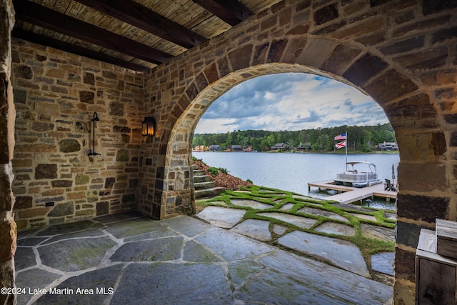 view of patio with a dock and a water view