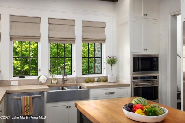 kitchen featuring butcher block countertops, sink, white cabinets, and stainless steel appliances