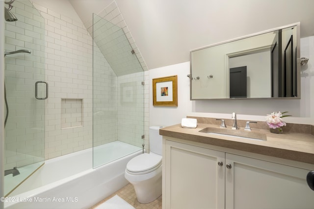 full bathroom with vanity, lofted ceiling, bath / shower combo with glass door, tile patterned flooring, and toilet