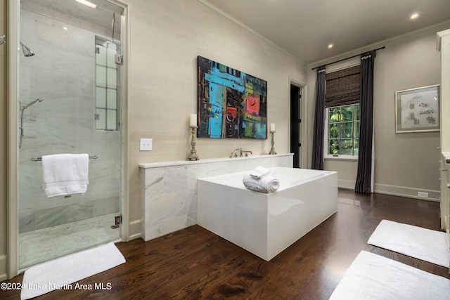 bathroom with hardwood / wood-style flooring, crown molding, and shower with separate bathtub