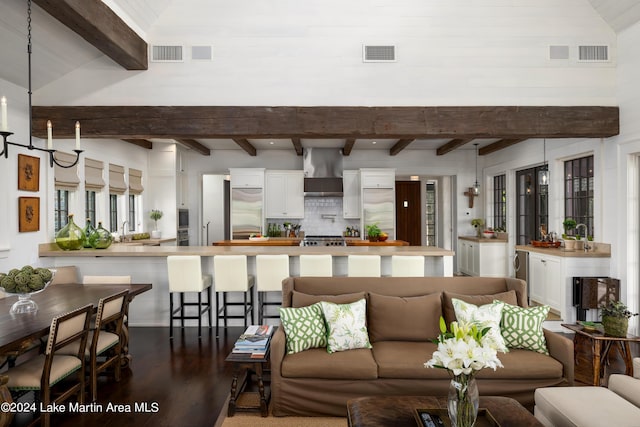 living room featuring beamed ceiling, wood-type flooring, sink, and high vaulted ceiling