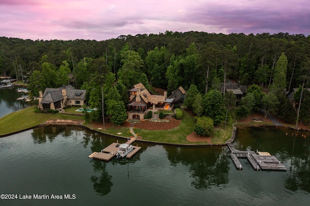 aerial view at dusk featuring a water view