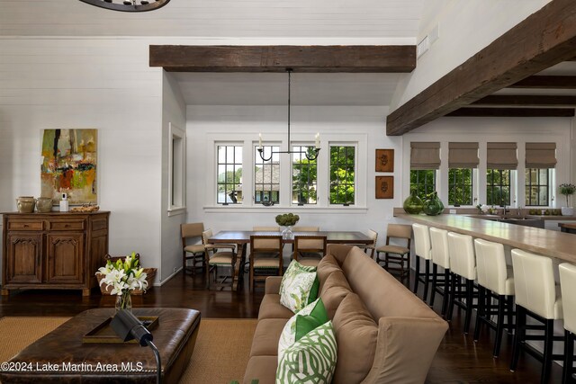 living room featuring beam ceiling, dark hardwood / wood-style flooring, and a notable chandelier