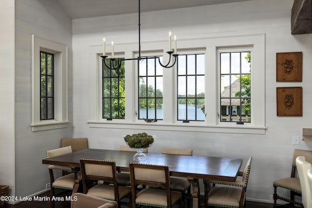 dining space with lofted ceiling, a healthy amount of sunlight, and a notable chandelier